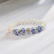 Kép 1/4 - Tejkvarc karkötő magyar motívumos porcelán gyönggyel ,rozetákkal ,shamballa beszúrással