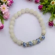 Kép 4/4 - Tejkvarc karkötő magyar motívumos porcelán gyönggyel ,rozetákkal ,shamballa beszúrással